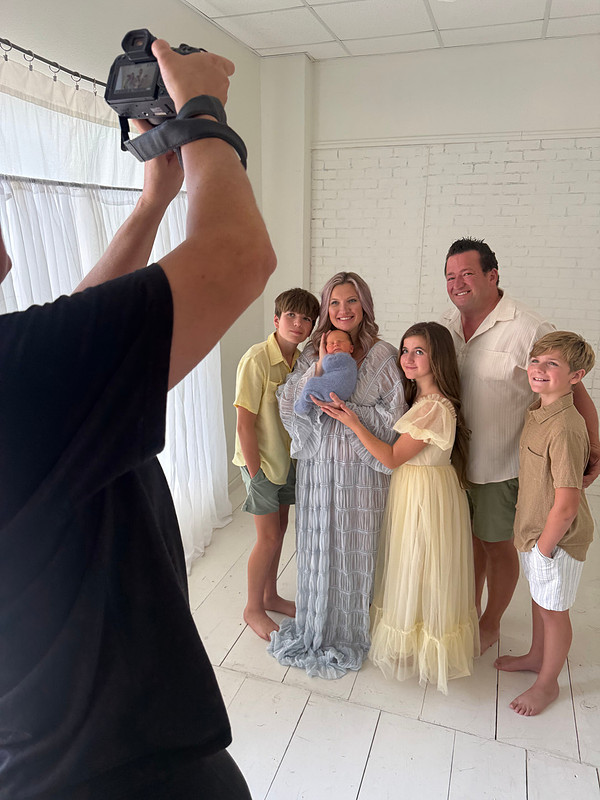 Teresa Carmouche photographing a family of six, including three older siblings and their newborn baby brother, during a studio newborn session in Gonzales, Louisiana.